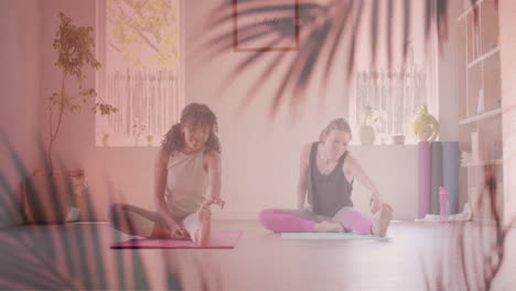 animation of palm leaves over happy diverse teenage girls practicing yoga together