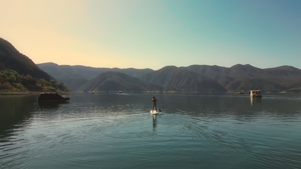 Tampilan Udara Seseorang Mendayung Papan Dayung di Danau Gunung yang Tenang