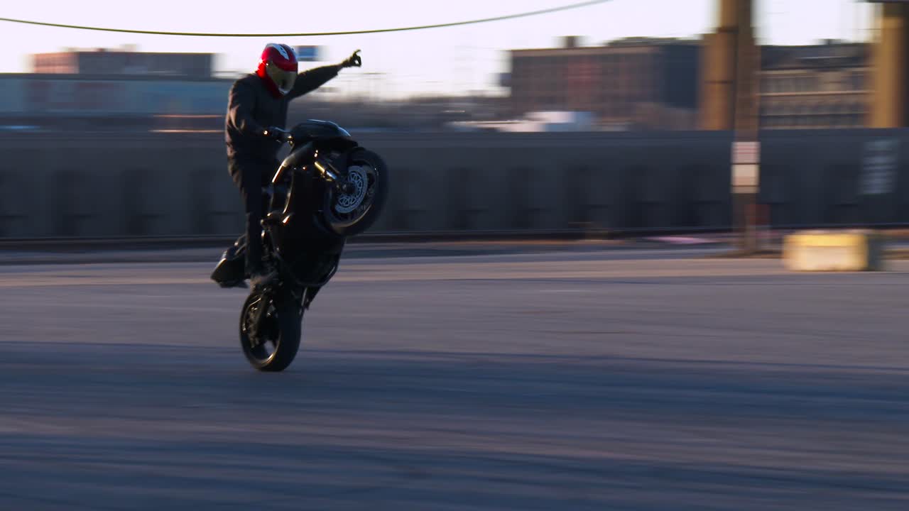 라이더는 주차장에서 오토바이에 곡예를 수행