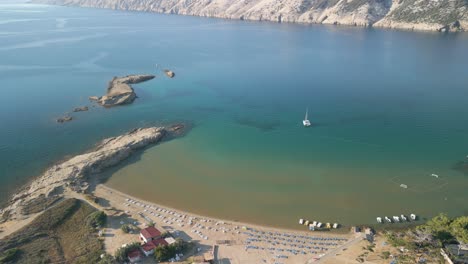 Lopar-aerial-view,-travel-holiday-destination-with-sandy-beach-and-pristine-sea-water,-traditional-town-on-Adriatic-coastline,-aerial-drone-view