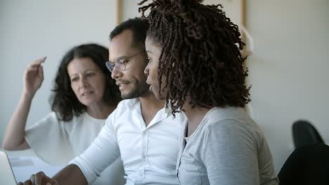 Successful-workers-talking-while-sitting-at-office