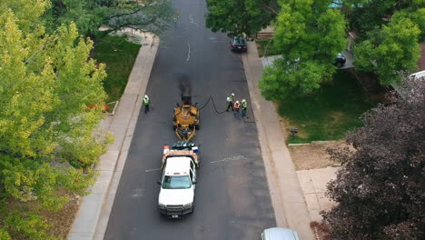 men filling the cracks in the road