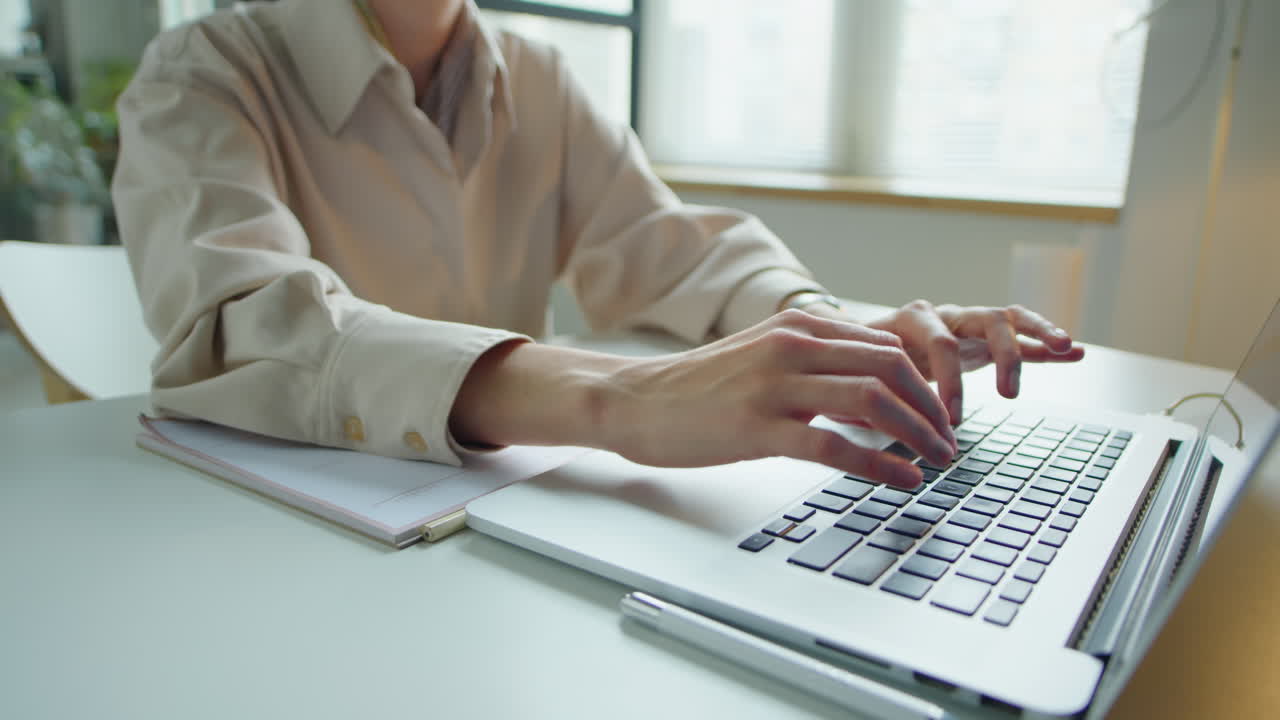 Woman Using Laptop at Desk in Office