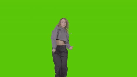 Full-Length-Studio-Shot-Of-Young-Woman-Having-Fun-Dancing-Against-Green-Screen