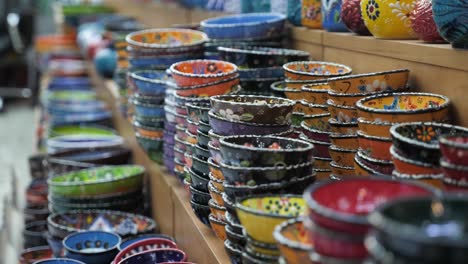 colorful pottery on store display, local ceramic product for sale, many plates