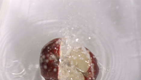 manzana cayendo en el agua en súper cámara lenta