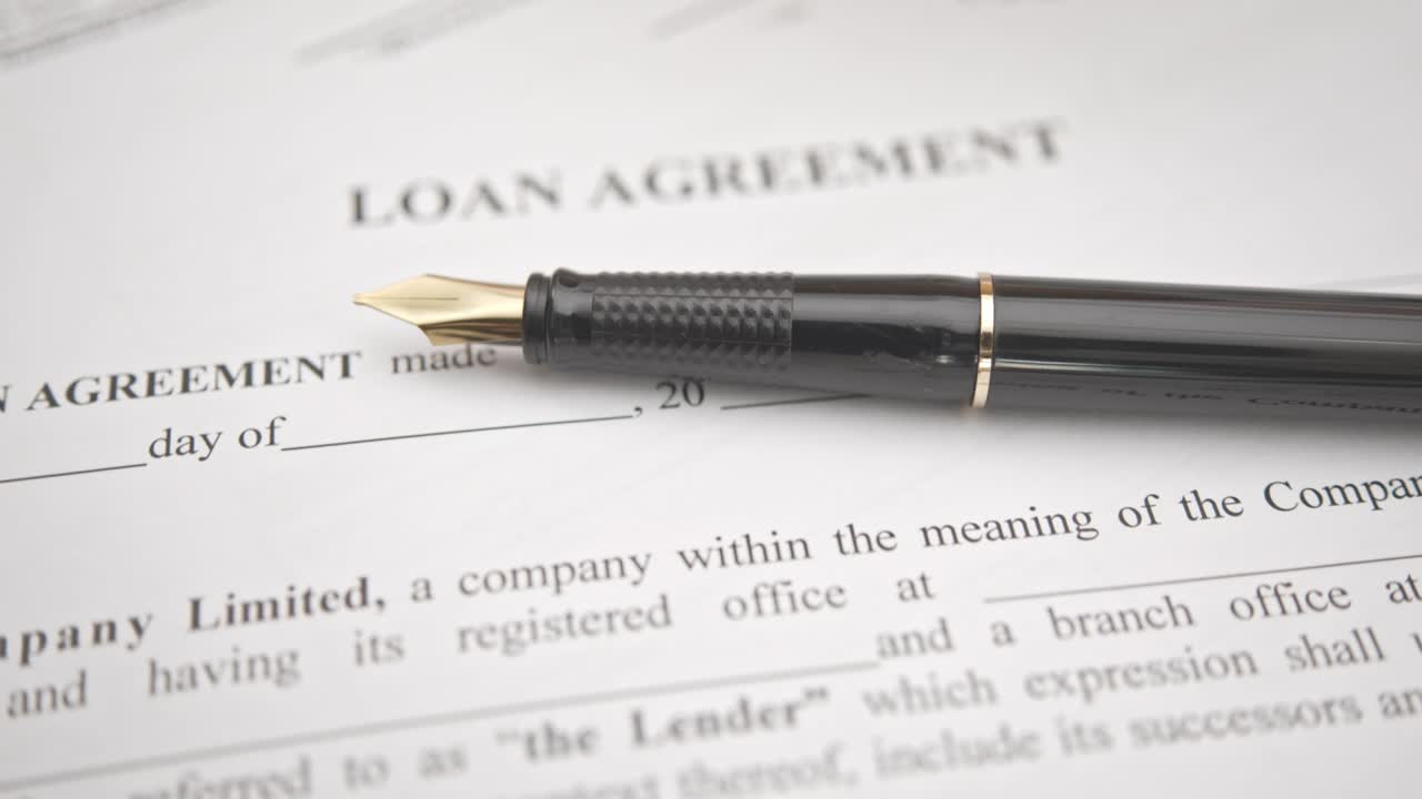 Business loan agreement or legal document concept : Fountain pen on a loan agreement paper form.
