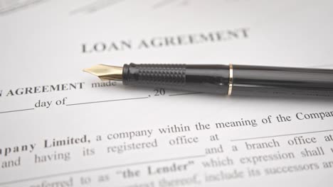 business loan agreement or legal document concept : fountain pen on a loan agreement paper form.