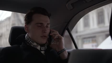 Attractive-Young-Guy-Talking-To-Someone-On-The-Phone-While-Riding-In-A-Car