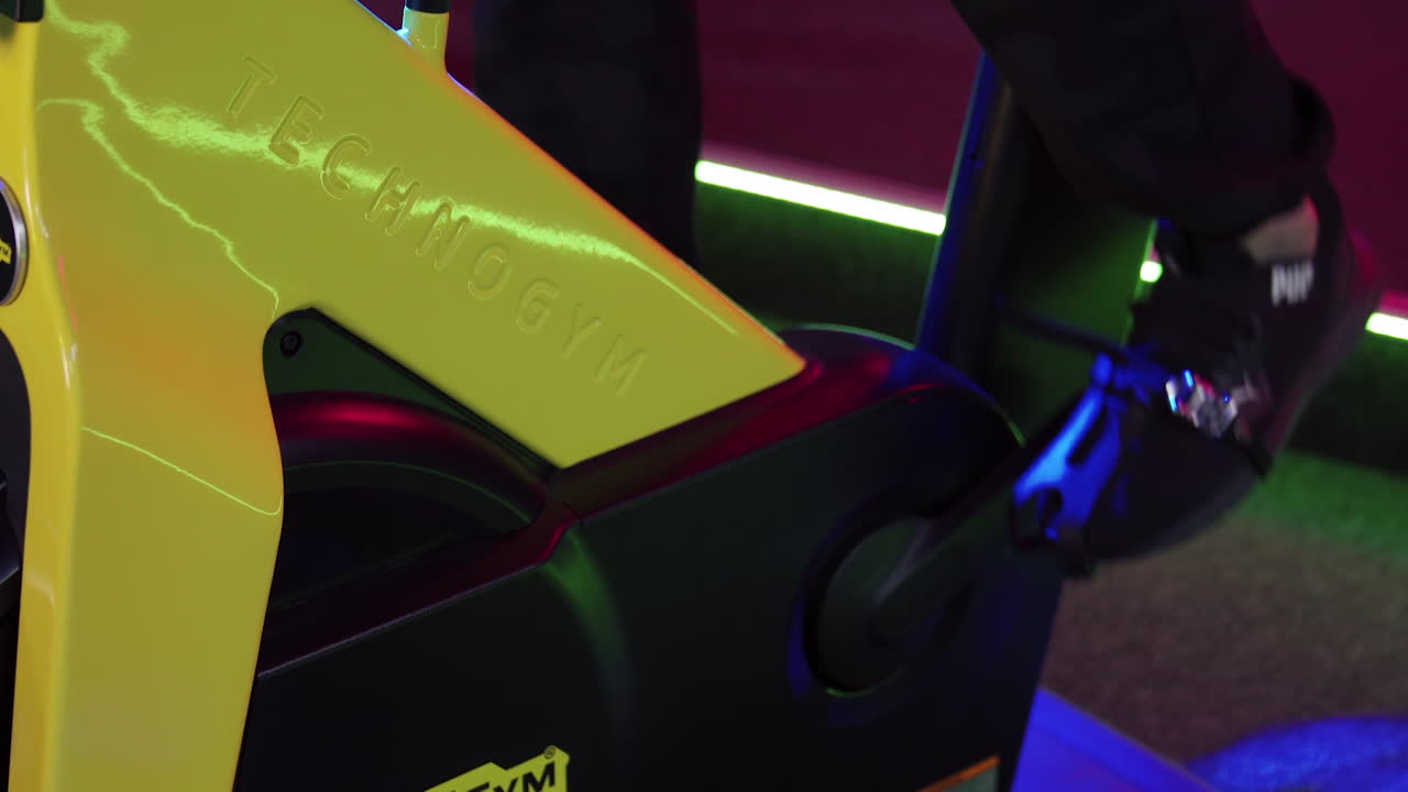 Speedy bicycle ride in fitness centre. Stationary bike cardio workout in sport gym