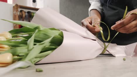 Empleado-De-La-Tienda-De-Flores-Afroamericana-Preparando-Un-Ramo-De-Flores-De-Tulipán,-Negocio-De-Arreglos-Florales