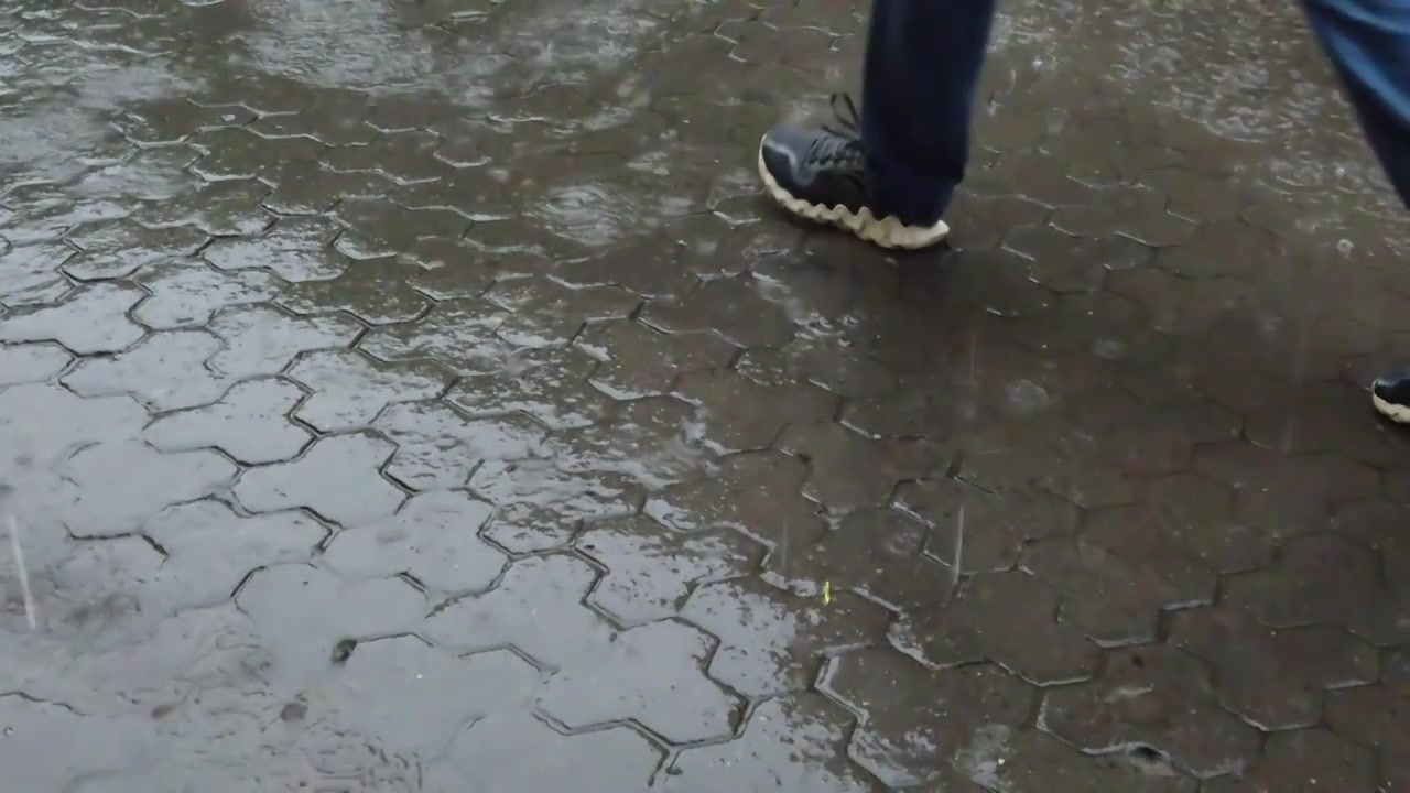 Rain in the city. Rain drops fall on the sidewalk.