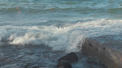 las olas rompen sobre la grada a lo largo de la costa en cámara lenta