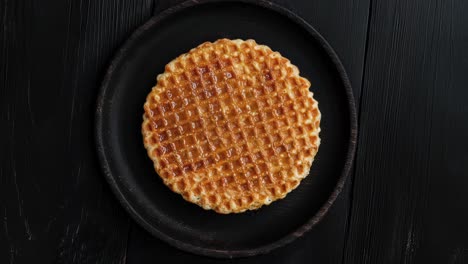 flat lay of stroopwafel on black wooden plate