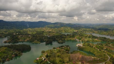 cinematic time lapse aerial above guatape sun reflection green islets blue water medellin colombia piedra del peñol top notch drone