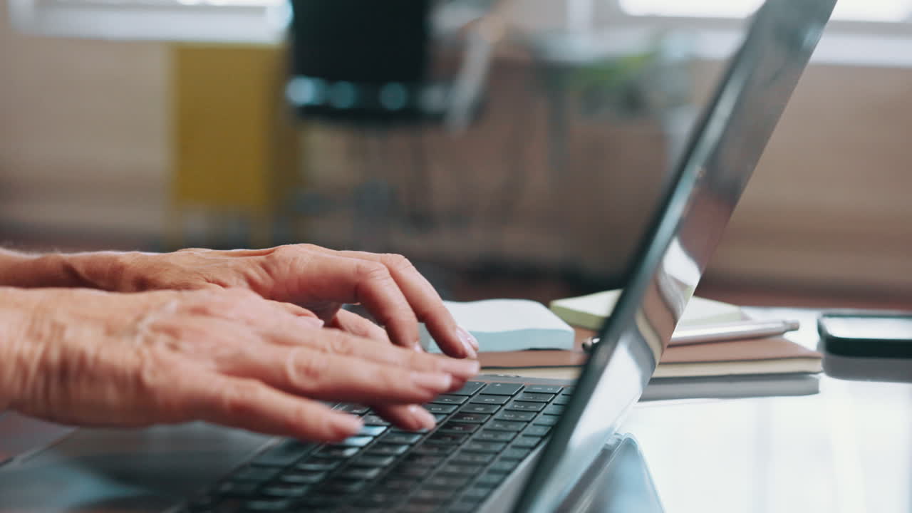 Close Up of Senior Woman Typing on Laptop Keyboard