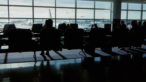 Silhouettes-of-passengers-in-the-airport-lounge