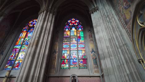 detailed view of an altar with vibrant stained glass windows inside votive church, vienna, austria