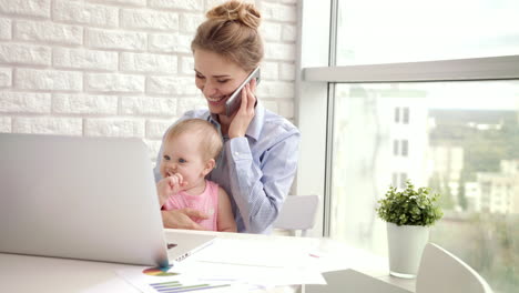 Working-woman-with-baby-speaking-phone.-Business-mom-with-child