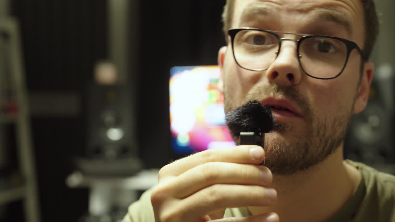 A social media influencer records a video using a small microphone. Concept of TikTok, YouTube, vlogging, and digital content creation trends