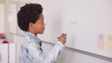 clase de matemáticas, niño escribiendo a bordo