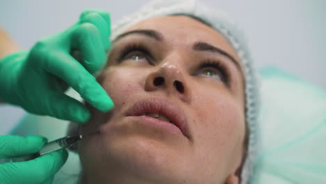 mujer se somete a una inyección de relleno facial antienvejecimiento en la clínica