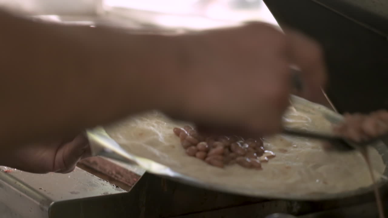 cocinar agregando frijoles a la tortilla de harina