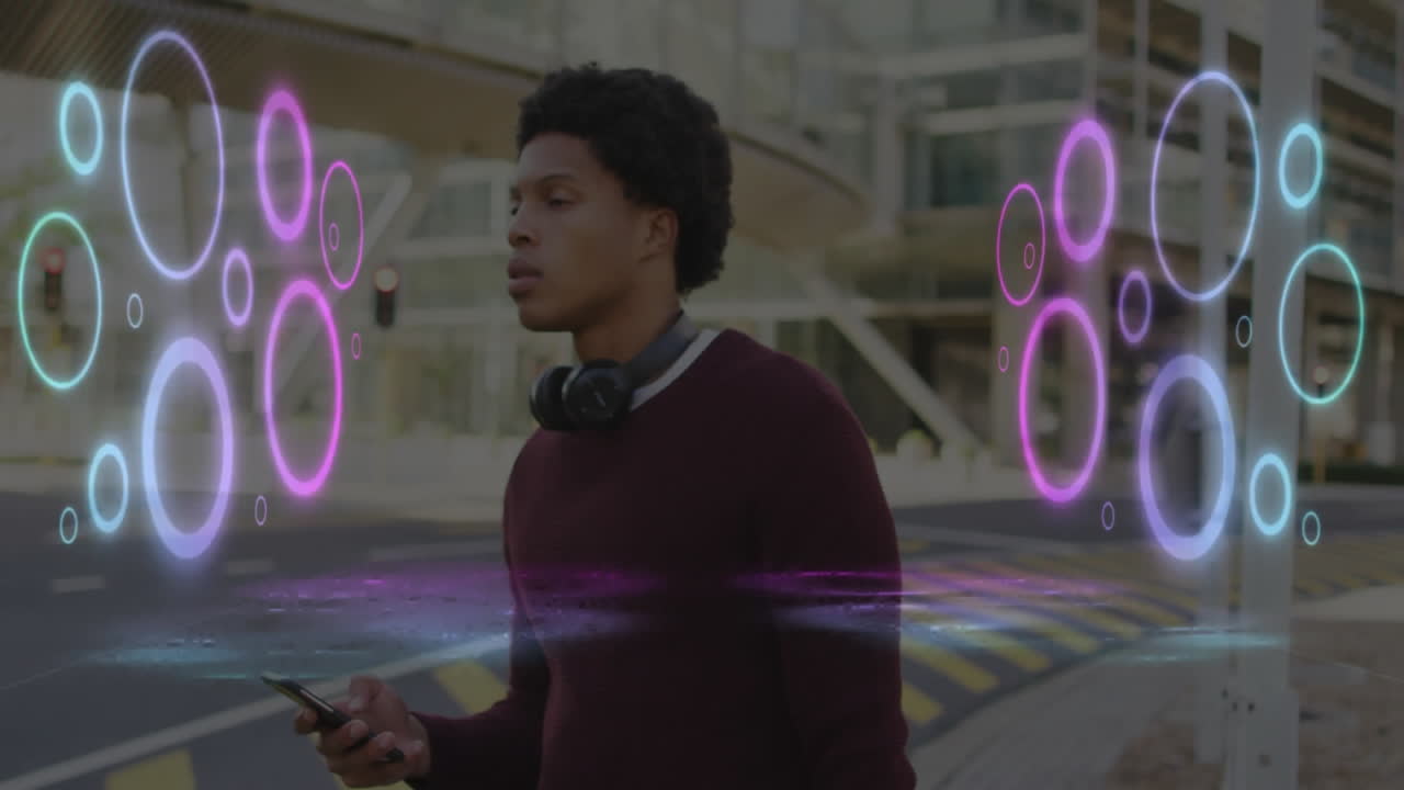 Man holding smartphone wearing headphones at urban intersection, neon rings illustrating AR tech