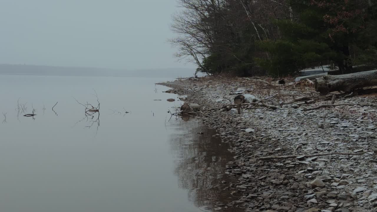 light, gentle snowfall on a beautiful, peaceful mountain lake, during a nor'easter, in the Appalachian mountains, on a calm winter's day