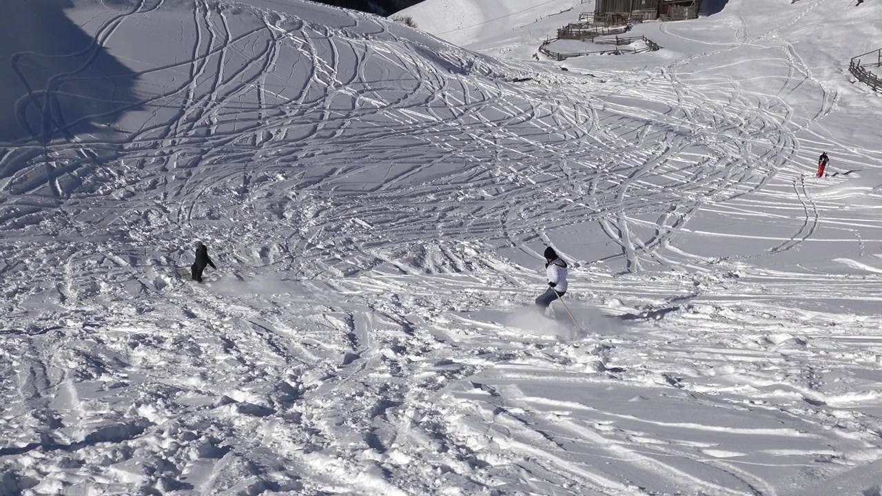 Skiers Descending Down a Snowy Mountain Slope