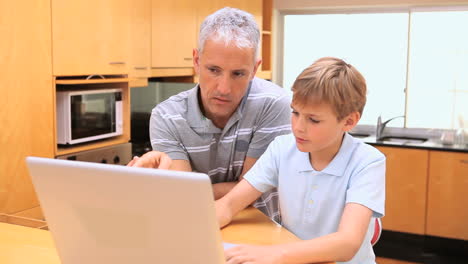 Little-boy-using-a-laptop-with-his-father