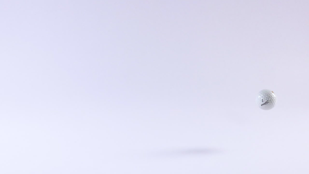 A golf ball moves across a white background