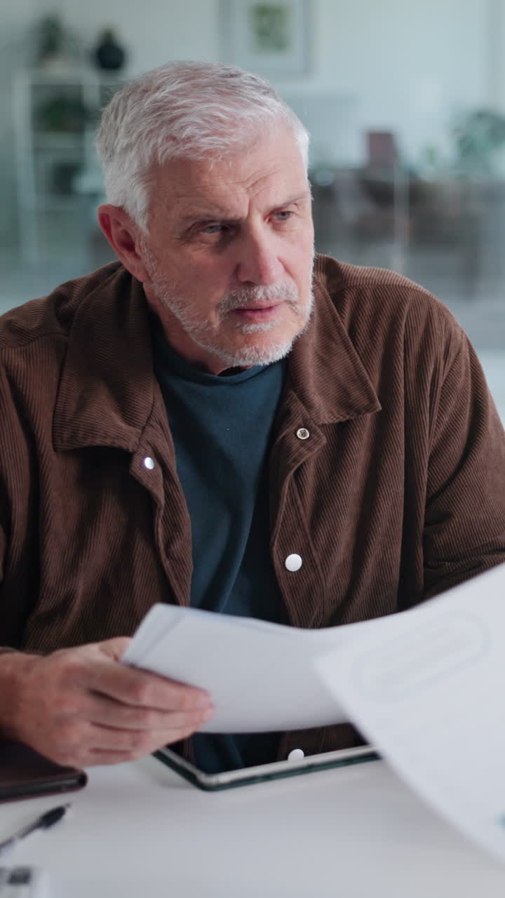Hombre mayor revisando documentos de negocios en un escritorio de oficina