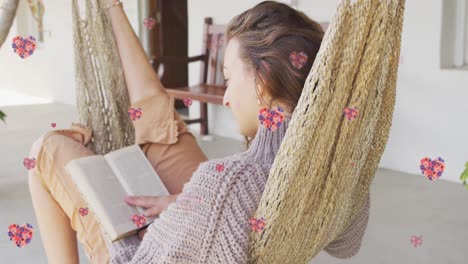 Animación-De-íconos-De-Corazón-Con-Flores-Sobre-Un-Libro-De-Lectura-De-Mujer-Birracial