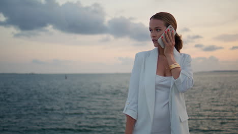 lady talking cellphone sunset marine view closeup. woman speaking smartphone