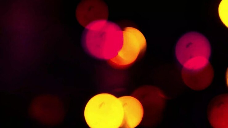 Luci bokeh colorate scintillanti su sfondo scuro.