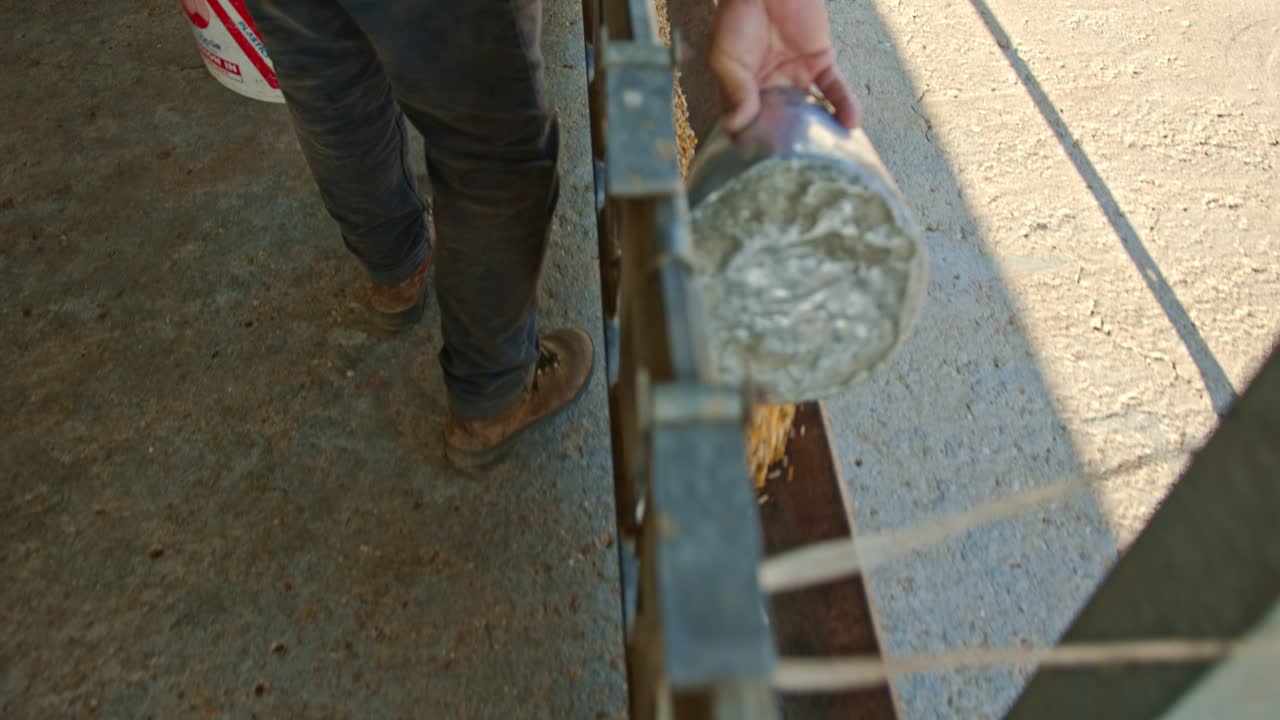 persona vertiendo alimento en el comedero para alimentar a las ovejas, toma de movimiento hacia atrás