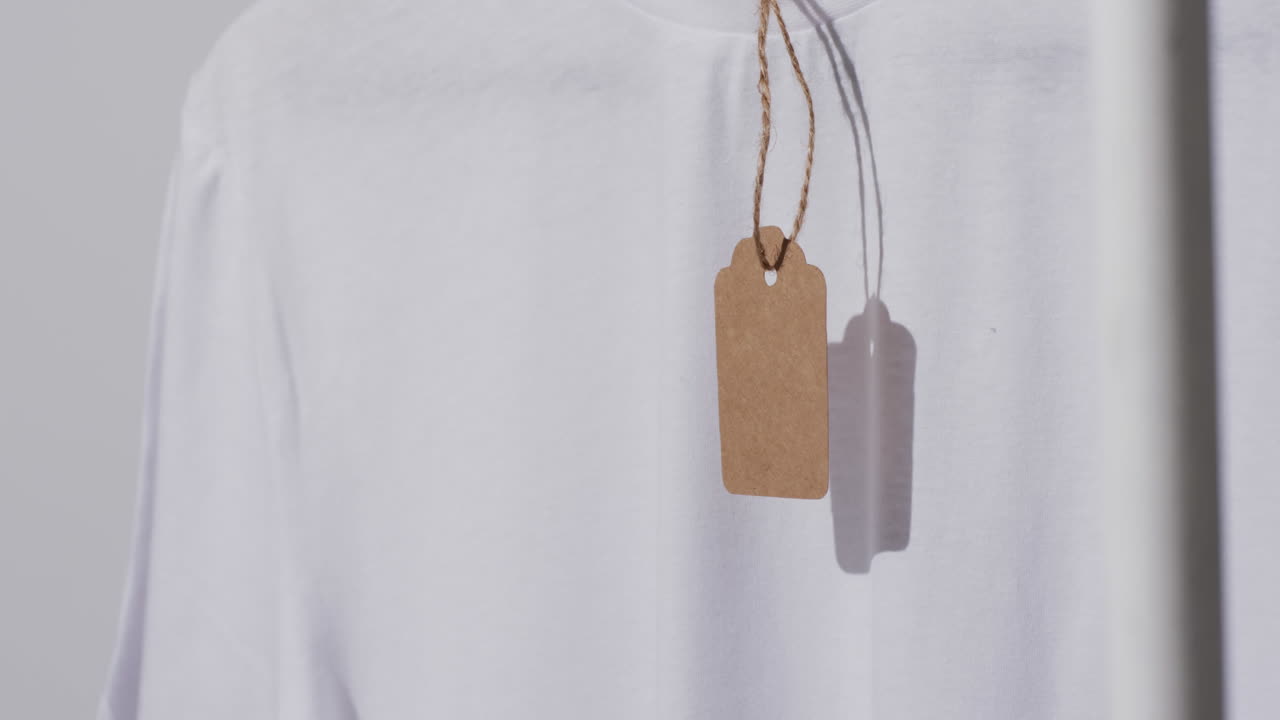 video di una maglietta bianca con tag e spazio di copia su sfondo grigio
