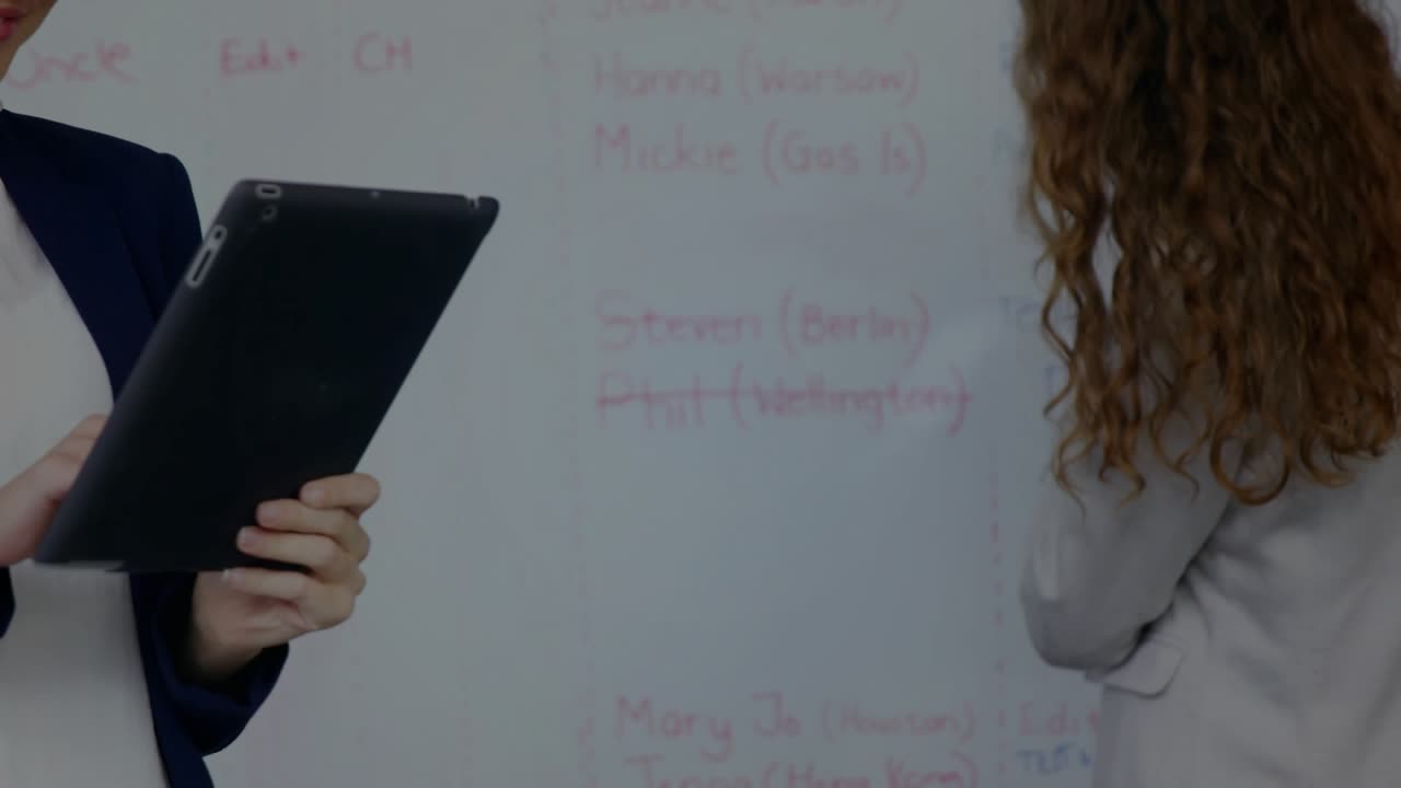 Left woman tapping tablet, animated DNA helix crossing tablet, camera centering reviewing science