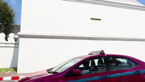 cars passing by the grand palace wall