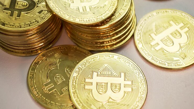 Bitcoin dorati impilati su sfondo bianco, inclinati verso l'alto: il futuro del denaro online con le criptovalute.