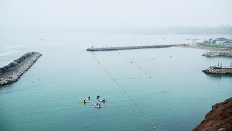 a group of people leisurely canoeing in the waters off the coast of club regatas in chorrillos, lima, peru