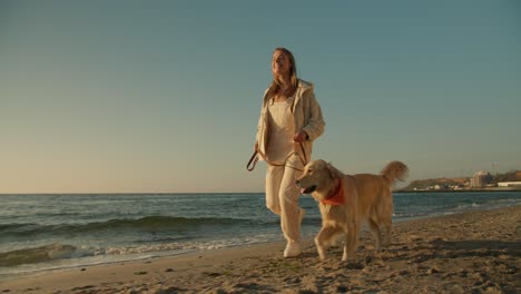 a morning run of a young blonde girl and her dog light coloring on a sunny beach in the morning