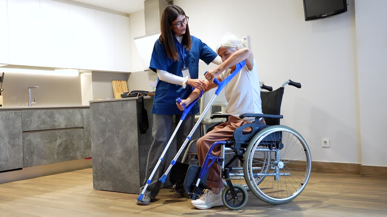 Nurse assisting elderly woman with crutches in her home
