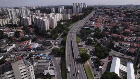 drone flying over a road with traffic in a sunny day in the city of são paulo