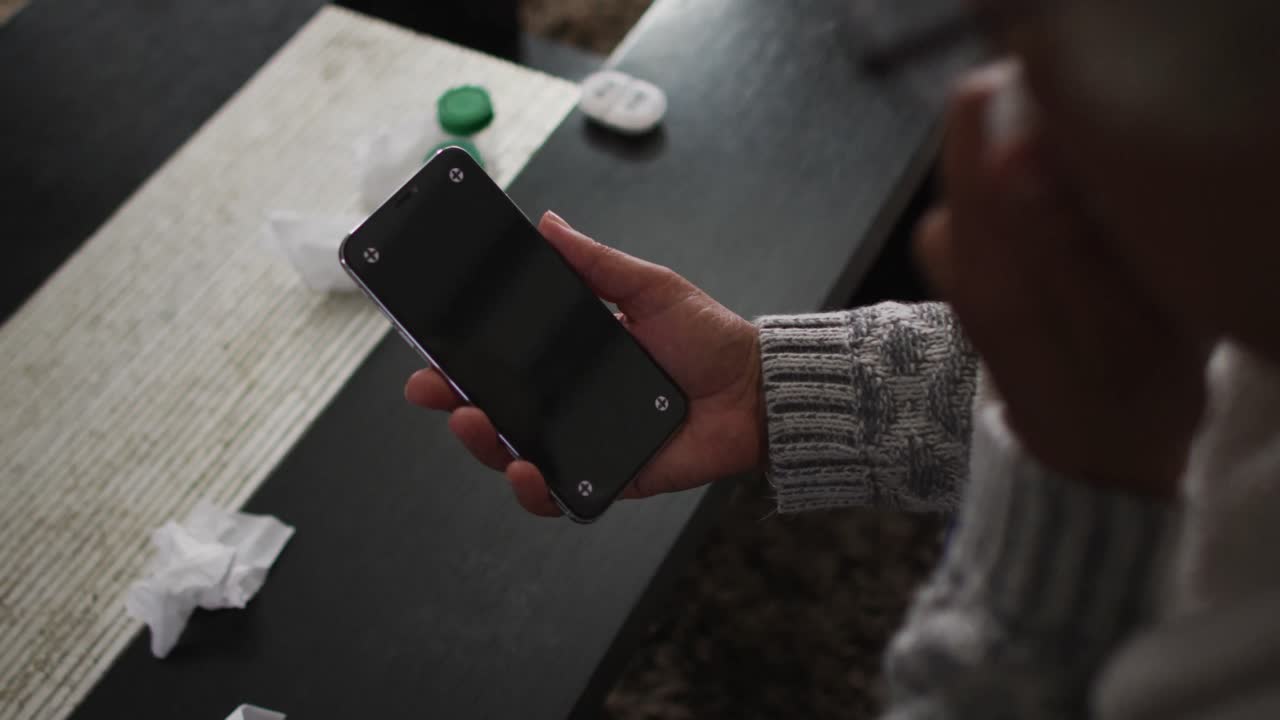 mujer mayor afroamericana enferma haciendo una videollamada en un teléfono inteligente con espacio de copia en casa