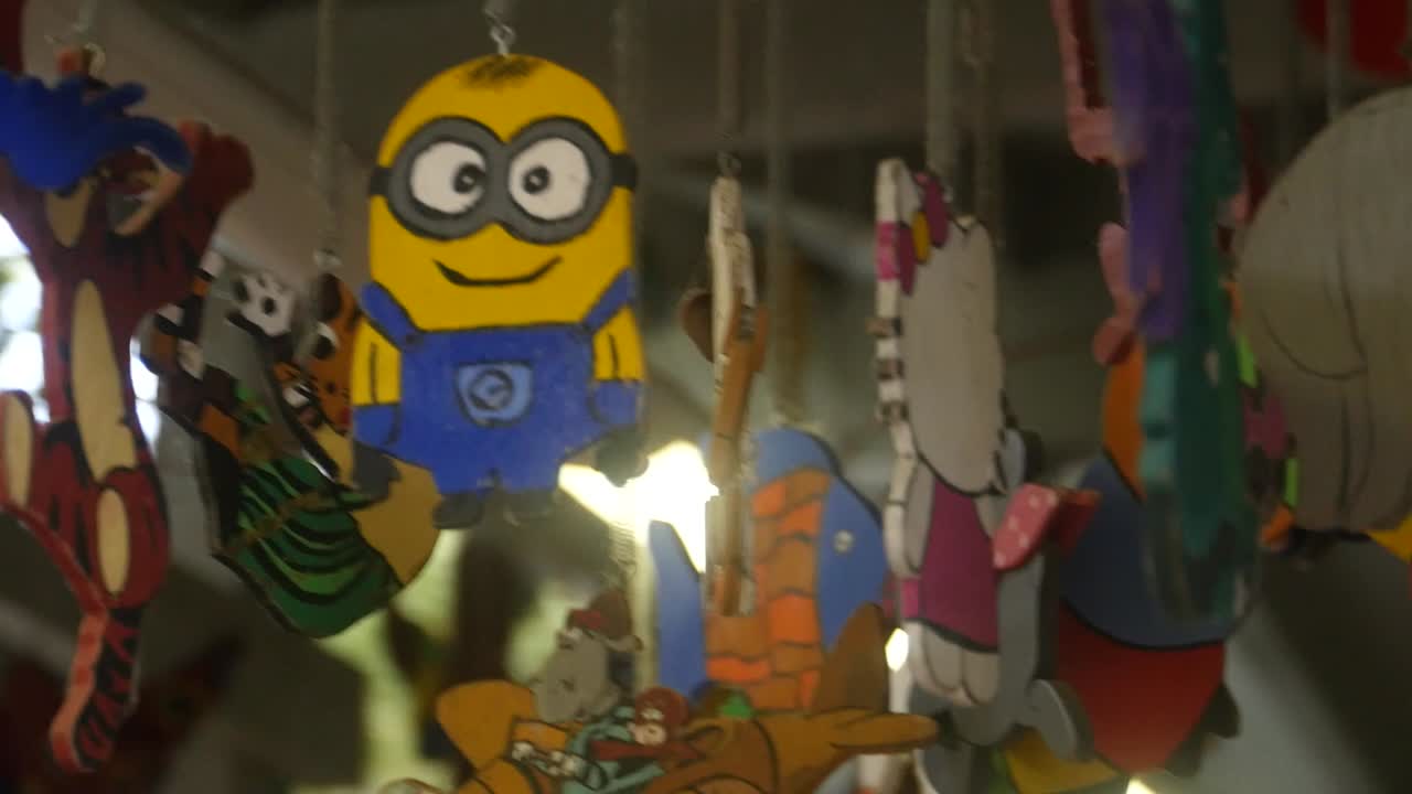 la cámara gira alrededor de una figura de madera de un minion, que cuelga del techo