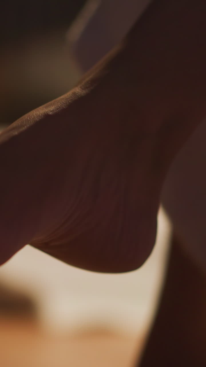 mujer elegante en vestido largo moviendo la pierna sentada en el sillón. la dama pone la pierna sobre la pierna y descansa después de un día agotador en el trabajo con la habitación borrosa en el fondo