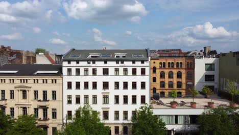 large white apartment house with huge roof terrace with trees