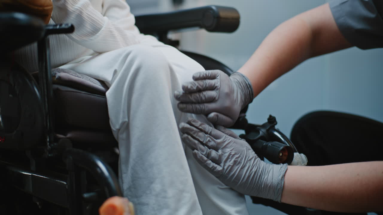 Caregiver assisting elderly woman in wheelchair